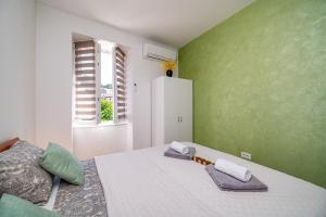 a bedroom with a large bed with green walls at SkyGarden House in Mali Lošinj