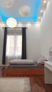 a bedroom with a bed with a window and two lights at Green Panda Apartments in Budapest