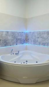 a white bath tub in a room with a wall at Green Panda Apartments in Budapest