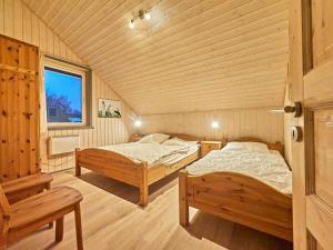 two beds in a wooden room with a window at Wildgans Classic 248 in Mirow