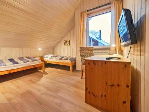 a room with two beds and a tv and a window at Wildgans Classic 249 in Mirow