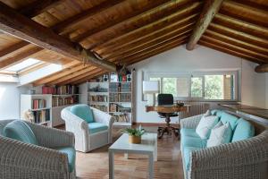 a living room with wooden ceilings and blue furniture at Casa Mancini Monticiano - Holiday Villa in Monticiano