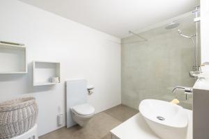 Un baño blanco con inodoro y lavabo. en Tulai H90, en Scuol