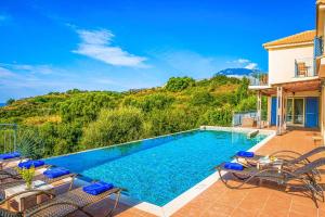 a villa with a swimming pool and patio furniture at Villa Louloudia in Ratzaklíon +16 photos