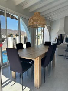 a dining room table with chairs and a chandelier at As056 Casa Amira - a modern house with pool in San Juan de los Terreros