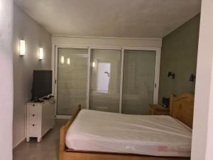 a bedroom with a large bed and a television at As056 Casa Amira - a modern house with pool in San Juan de los Terreros
