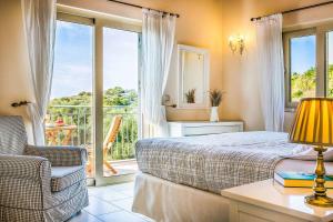 a bedroom with a bed and a view of a balcony at Villa Louloudia in Ratzaklíon