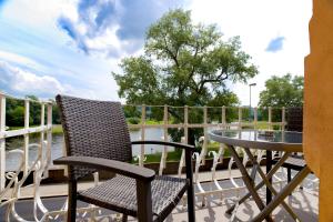 a table and chairs on a deck with a table and a table and a glass at Apartmány Děčín in Děčín