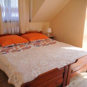 a bedroom with a large bed with orange pillows at Kapio Solina Bieszczady Bóbrka in Bóbrka