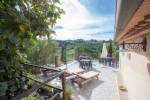 patio ze stołem i krzesłami w obiekcie Garden Relais Le Fontanelle w mieście Montescudaio