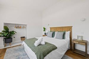 a bedroom with a large bed with a green blanket at 1930's Character Cottage - Beautifully Restored in McLaren Vale