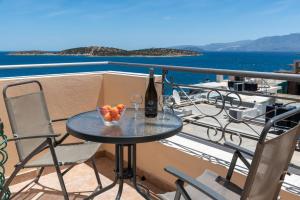 a table with a bottle of wine and fruit on a balcony at Evangelia cozy View in Agios Nikolaos