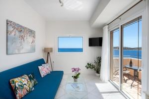 a living room with a blue couch and a view of the ocean at Evangelia cozy View in Agios Nikolaos +2 photos