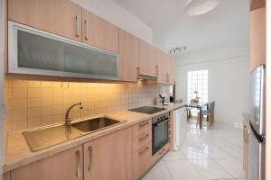 a kitchen with wooden cabinets and a sink and a table at Evangelia cozy View in Agios Nikolaos