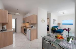 a kitchen and living room with a bowl of fruit on a table at Evangelia cozy View in Agios Nikolaos