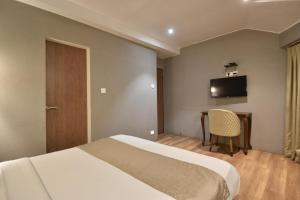 Postel nebo postele na pokoji v ubytování The Aarya A Smart Business Hotel