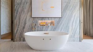 a white bath tub in a bathroom with a wall at Jumeirah Al Naseem Dubai in Dubai