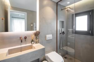 a bathroom with a sink and a shower and a toilet at Maya Luxury Residence in Aegenitissa +9 photos