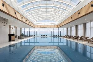 a large pool with chairs and a glass ceiling at Annabelle Studio in Batumi