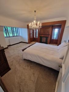 a bedroom with a large bed and a chandelier at Oakenclough Hall in Macclesfield