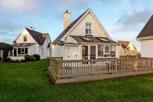 a house with a wooden fence in the yard at Sunny Cottage in Wexford