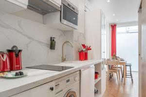 uma cozinha branca com um lavatório e uma máquina de lavar louça em Lavie Maison Eiffel AC Hot Tub em Paris
