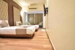 Postel nebo postele na pokoji v ubytování The Aarya A Smart Business Hotel