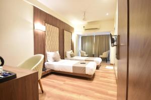 Postel nebo postele na pokoji v ubytování The Aarya A Smart Business Hotel