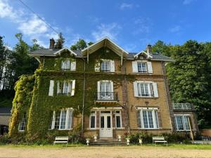 an old house with ivy on the side of it at Private Oasis: Luxe 20-guest Estate, Jacuzzi, 8 Ha in Bazeilles
