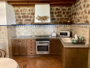 een keuken met een fornuis en een wastafel bij El Portal de Vilafamés in Vilafames