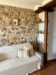 een woonkamer met een stenen muur en een bank bij El Portal de Vilafamés in Vilafames