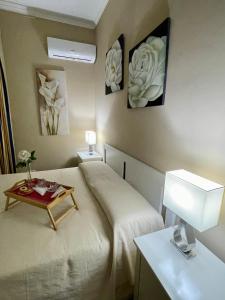 a bedroom with a bed with a table on it at Appartamento piscina&mare in Lido di Ostia