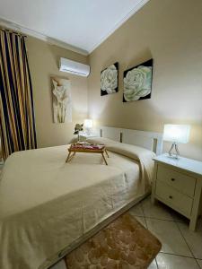 a bedroom with a large bed with a table on it at Appartamento piscina&mare in Lido di Ostia