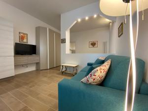 Una sala de estar con un sofá azul y un televisor. en Urban Nest Terrace Suite, en Bolonia