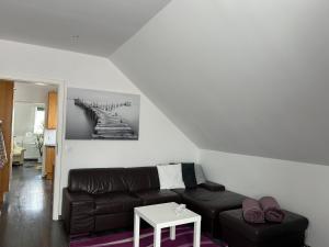 sala de estar con sofá negro y mesa en Wolfenbüttler Apartment, en Wolfenbüttel