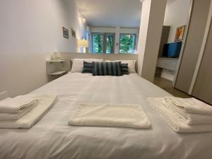 Una cama blanca grande con toallas encima. en Urban Nest Terrace Suite, en Bolonia