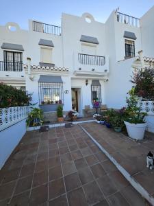 Casa blanca con patio con macetas en Cozy Duplex Niza Beach, en Torre del Mar