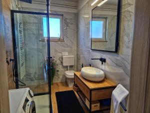 a bathroom with a toilet and a sink and a shower at APARTMAN MARE-PEROJ in Vodnjan