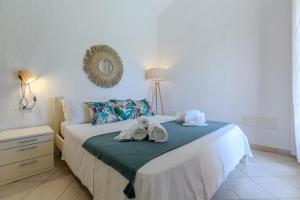 - une chambre avec un lit, des serviettes et un miroir dans l'établissement Villette con piscina zona Porto Pino, à SantʼAnna Arresi