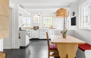 a kitchen with a wooden table and a dining room at 3 Bedroom Beautiful Home In Ølsted in Ølsted