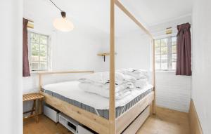 a bedroom with a bed with a wooden frame at 3 Bedroom Beautiful Home In Ølsted in Ølsted