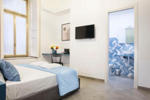 a white room with a bed and a tv at Bausan Avenue in Naples