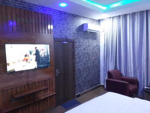 a room with a tv on a brick wall at Exclusive mansion lekki phase 1 in Ilado