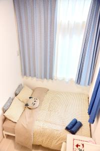 a small bedroom with a bed and a window at 宿栖渋谷 in Tokyo