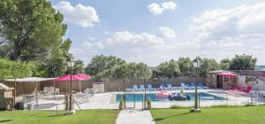 ein Swimmingpool mit Stühlen und Sonnenschirmen in einem Garten in der Unterkunft Abantos LA CASA DE GALAPAGAR in Galapagar