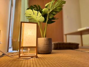 a table with a candle and a vase with a plant at ura tomari in Okayama