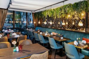 a restaurant with wooden tables and chairs and vines at Landhaus Danielshof in Bedburg