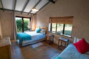 a bedroom with two beds and a window at Kokopelli farm in Magaliesburg