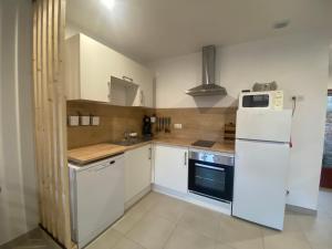 a kitchen with a white refrigerator and a stove at La Riolle in Bracieux