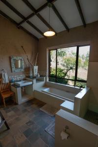 a bathroom with a tub and a sink and a window at Kokopelli farm in Magaliesburg